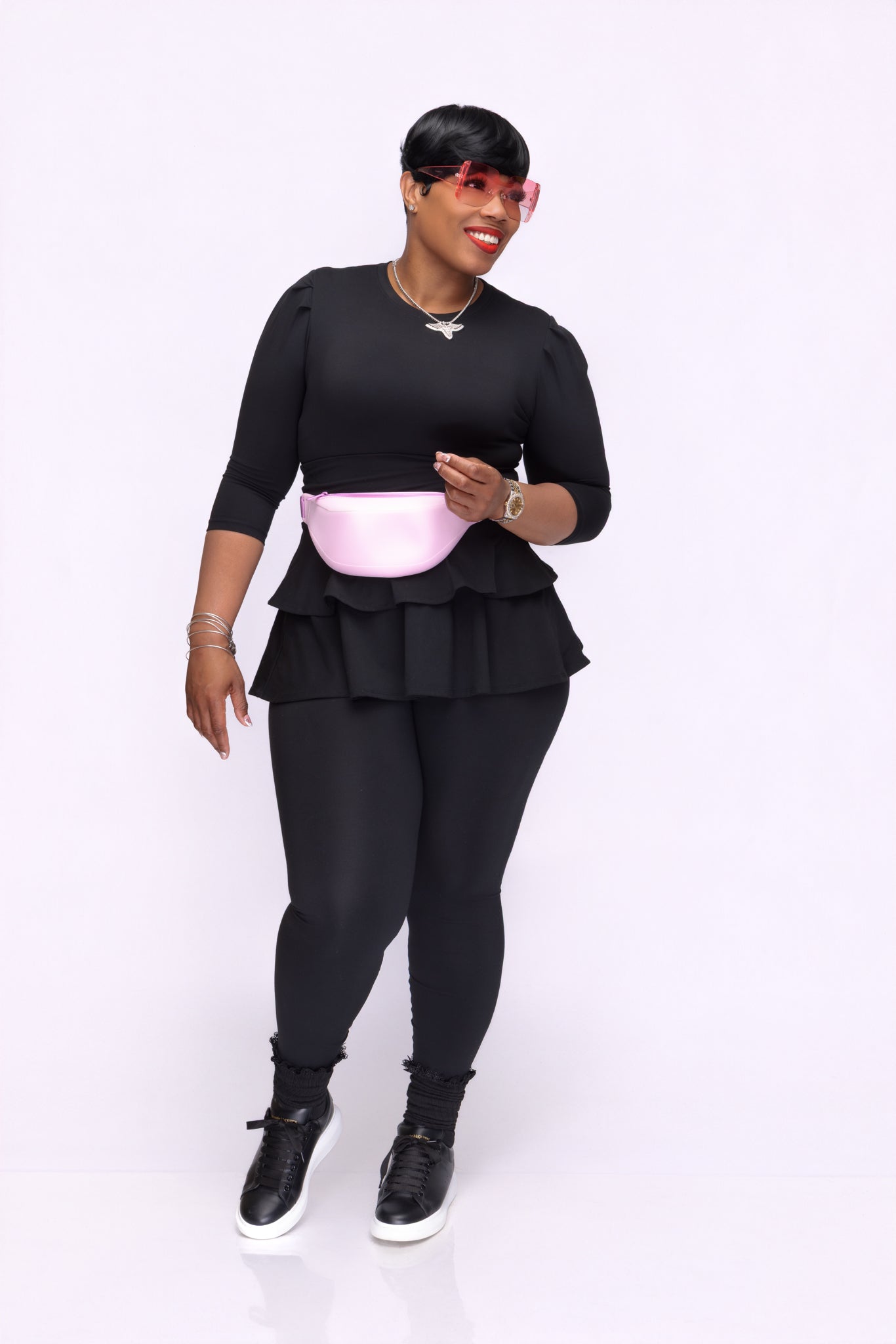 Stylish woman wearing a black Pooh Wear Work to Workout athletic outfit with Pooh Wear Work to Workout pink pouch (fanny pack).