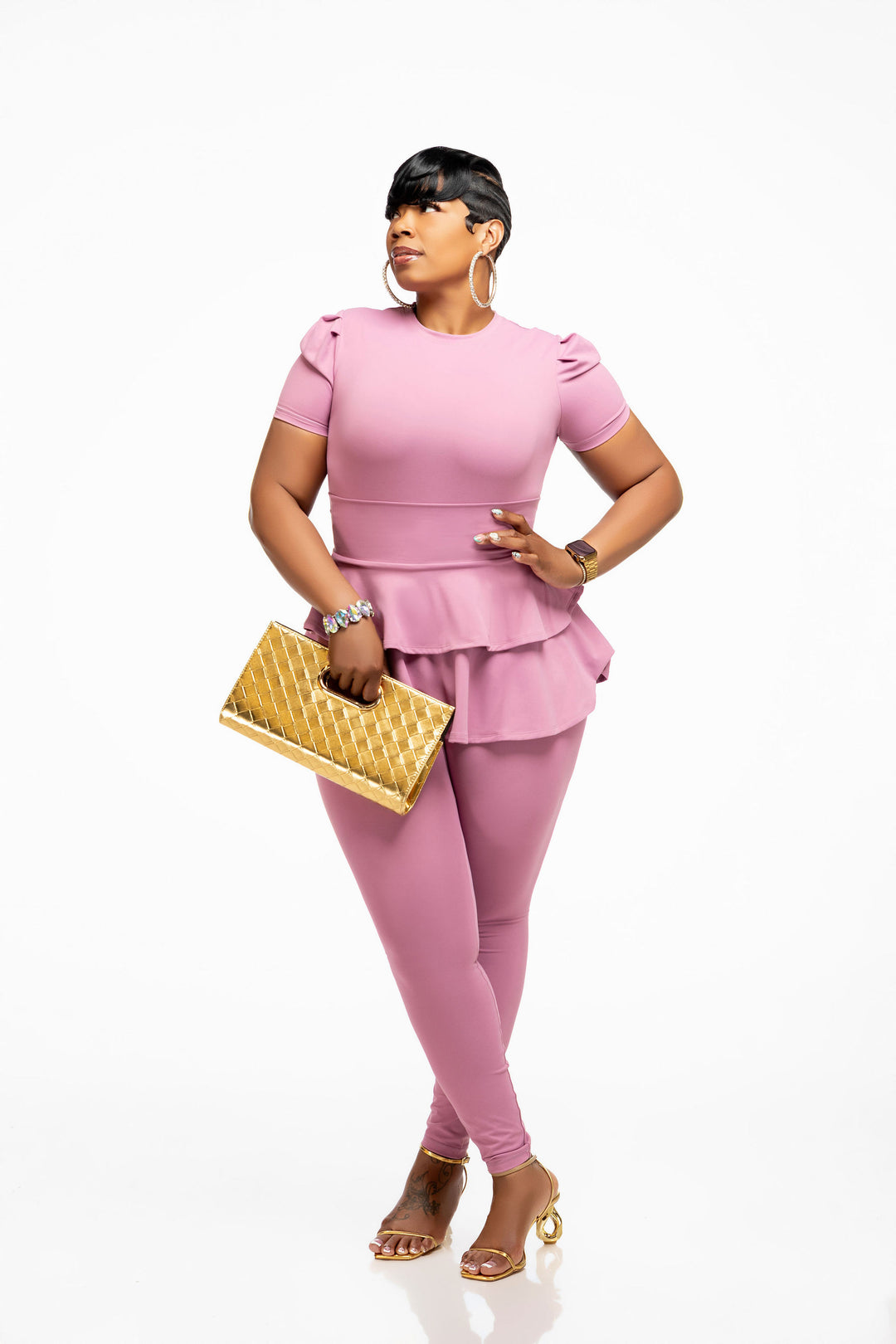 Woman wearing a pink Pooh Wear Work to Workout top , peplum skirt and leggings set on a white background