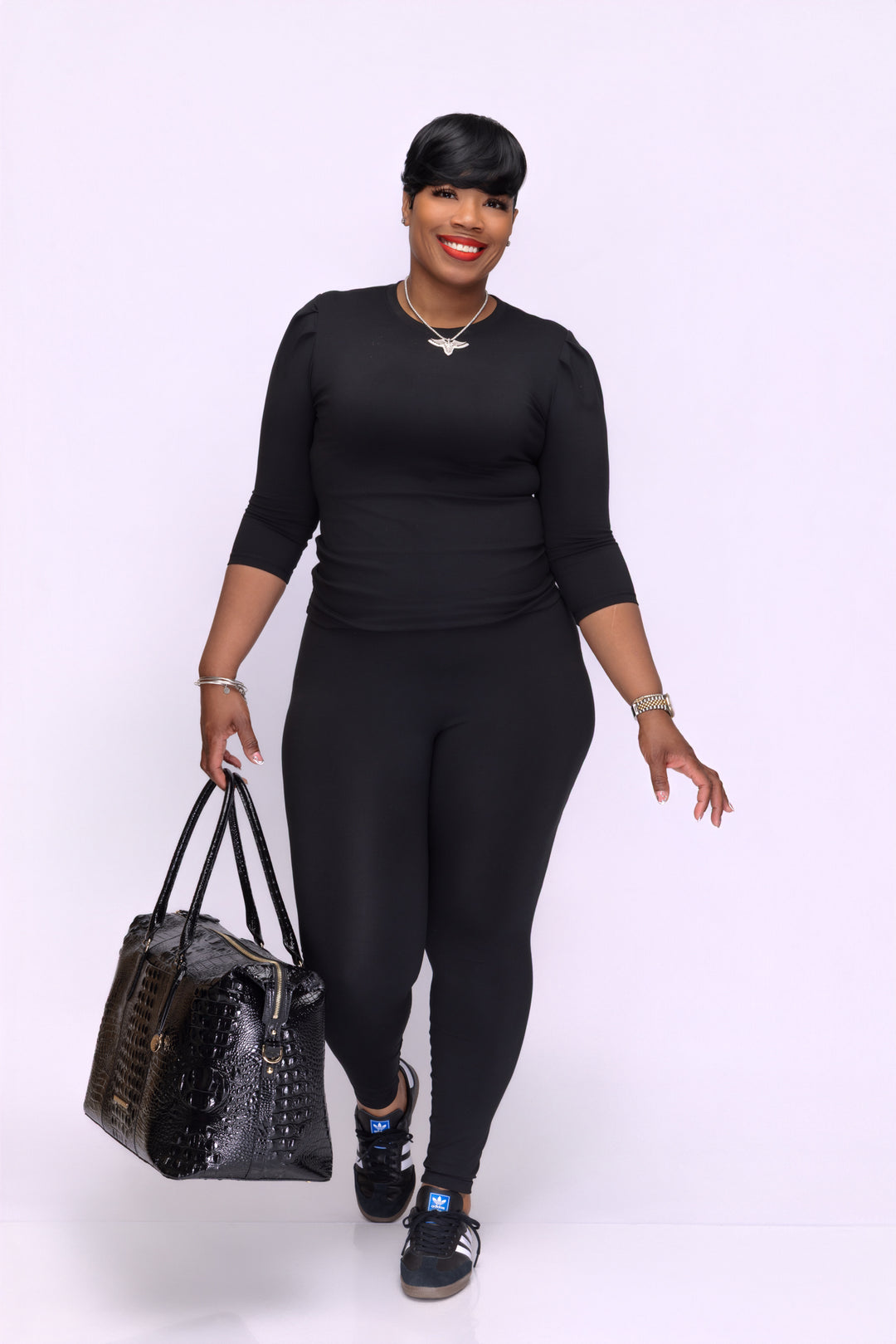 Stylish woman wearing an Pooh Wear athletic outfit with a luxury weekender bag