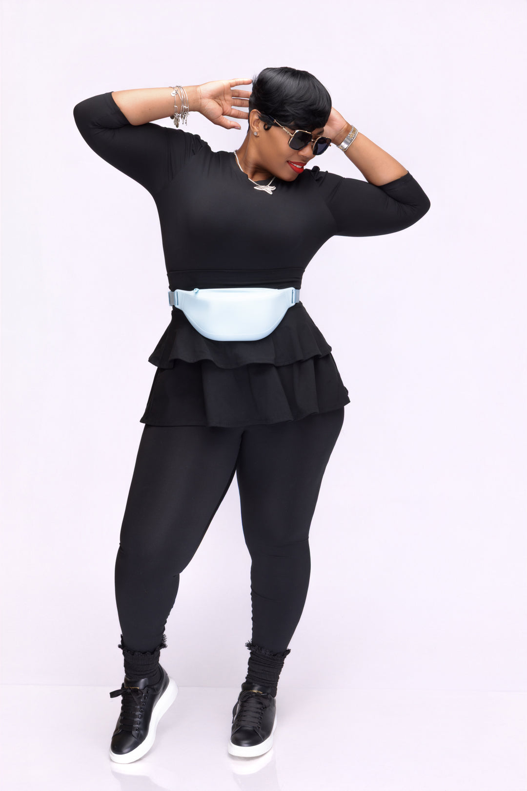 Stylish woman wearing a black Pooh Wear Work to Workout athletic outfit with Pooh Wear Work to Workout blue pouch (fanny pack).