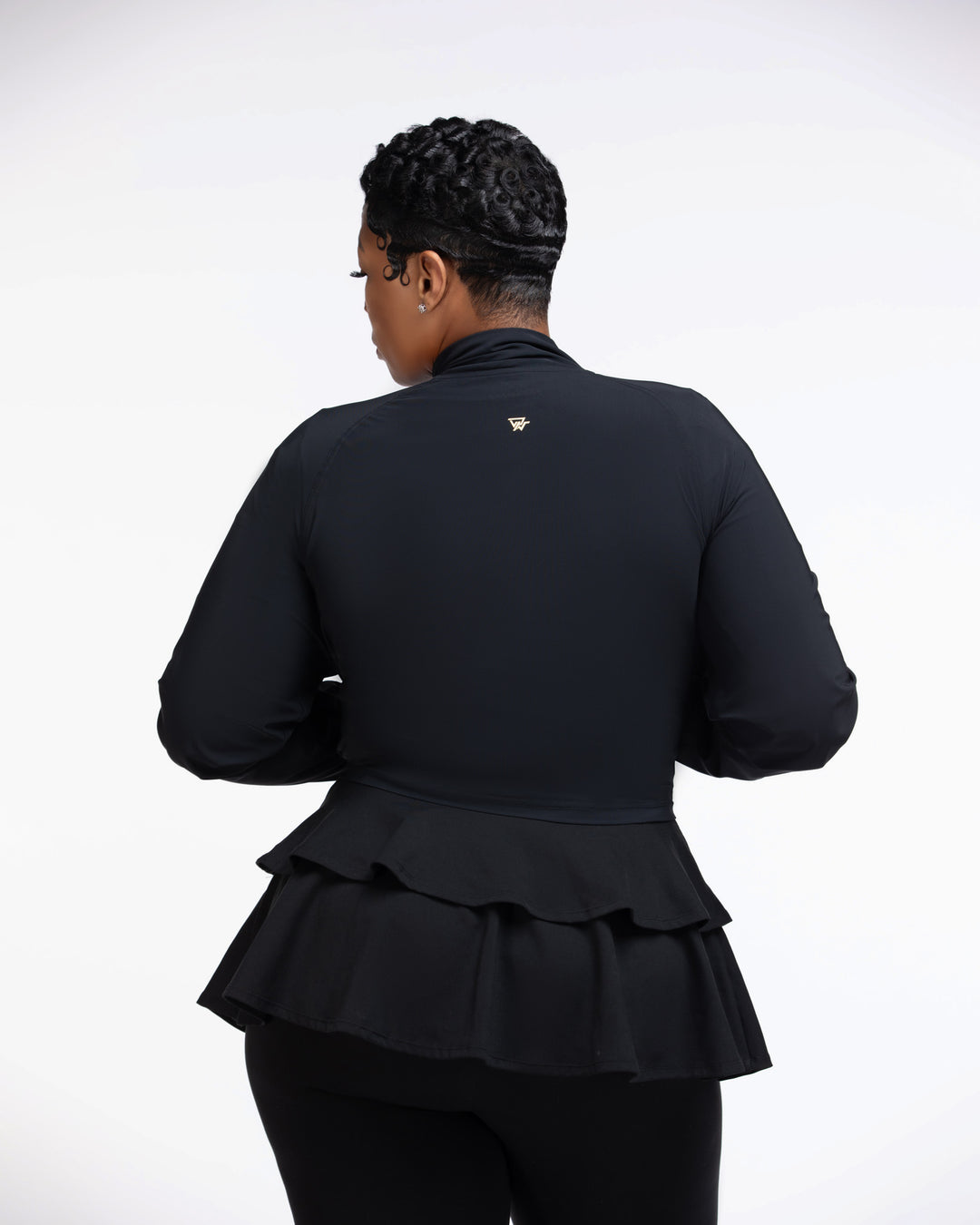 Person wearing a black peplum jacket on a white background