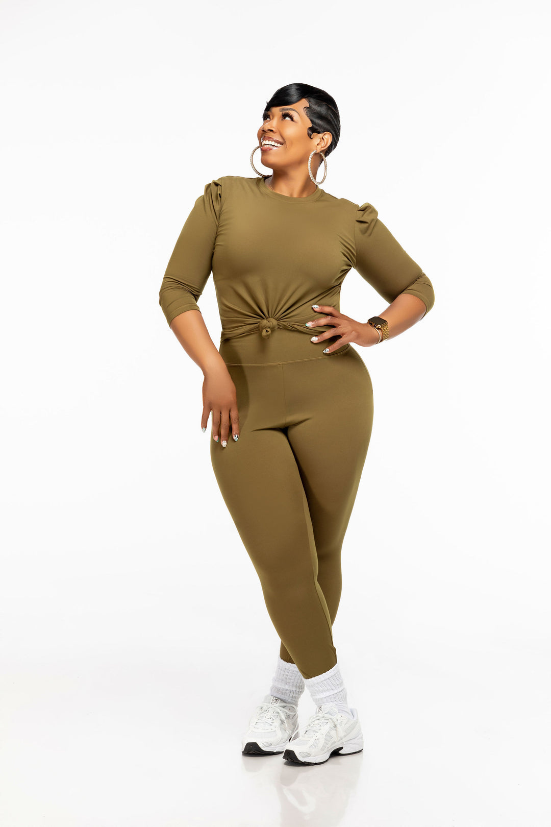 Woman wearing a green Pooh Wear Work to Workout top , peplum skirt and leggings set on a white background